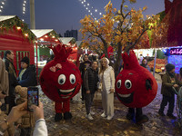 Iranian women pose for photographs with two pomegranate-shaped dolls during a pomegranate festival on Yalda Night Eve in the Abasabad touris...