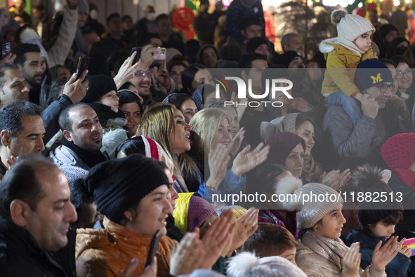 Two young Iranian women clap while participating in a pomegranate festival on Yalda Night Eve in the Abasabad tourism zone in central Tehran...