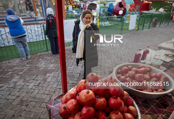 An Iranian woman looks at pomegranates while visiting a pomegranate festival on Yalda Night Eve in the Abasabad tourism zone in central Tehr...