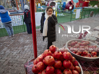 An Iranian woman looks at pomegranates while visiting a pomegranate festival on Yalda Night Eve in the Abasabad tourism zone in central Tehr...