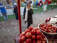 An Iranian woman looks at pomegranates while visiting a pomegranate festival on Yalda Night Eve in the Abasabad tourism zone in central Tehr...