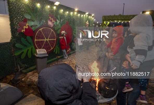 Young Iranian girls pose for photographs in front of Yalda decorations during a pomegranate festival on Yalda Night Eve in the Abasabad tour...