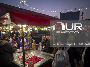 Young Iranian people wait to receive pomegranate ice cream while visiting a pomegranate festival on Yalda Night Eve in the Abasabad tourism...