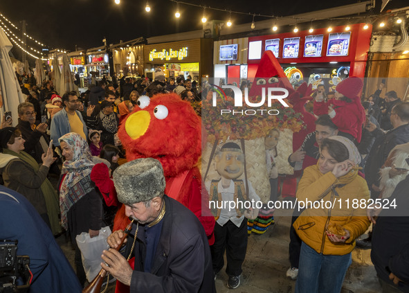 Iranian performers perform during a pomegranate festival on Yalda Night Eve in the Abasabad tourism zone in central Tehran, Iran, on Decembe...