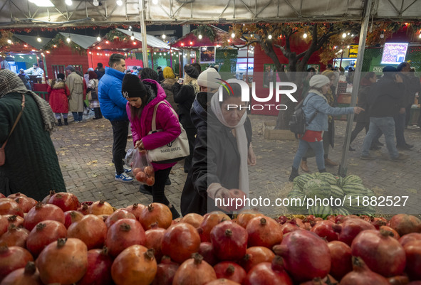 An Iranian woman collects pomegranates while shopping for the Yalda Night ceremony during a pomegranate festival in the Abasabad tourism zon...