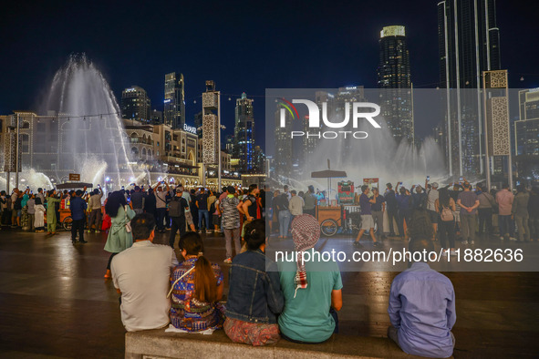 Tourists watch a water show of the Dubai Fountain at Burj Khalifa Lake in Dubai, United Arab Emirates on November 29, 2023.  