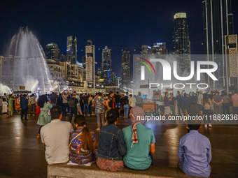 Tourists watch a water show of the Dubai Fountain at Burj Khalifa Lake in Dubai, United Arab Emirates on November 29, 2023.  (