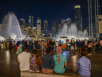 Tourists watch a water show of the Dubai Fountain at Burj Khalifa Lake in Dubai, United Arab Emirates on November 29, 2023.  (