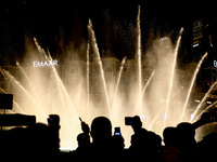 Tourists watch a water show of the Dubai Fountain at Burj Khalifa Lake in Dubai, United Arab Emirates on November 29, 2023.  (