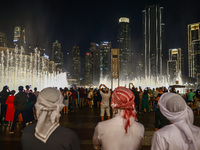 Tourists watch a water show of the Dubai Fountain at Burj Khalifa Lake in Dubai, United Arab Emirates on November 29, 2023.  (