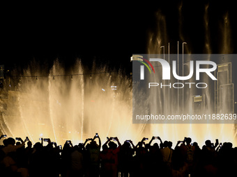 Tourists watch a water show of the Dubai Fountain at Burj Khalifa Lake in Dubai, United Arab Emirates on November 29, 2023.  (