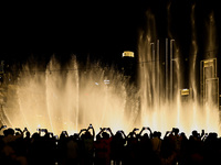 Tourists watch a water show of the Dubai Fountain at Burj Khalifa Lake in Dubai, United Arab Emirates on November 29, 2023.  (