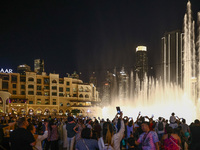 Tourists watch a water show of the Dubai Fountain at Burj Khalifa Lake in Dubai, United Arab Emirates on November 29, 2023.  (