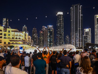 Tourists watch a water show of the Dubai Fountain at Burj Khalifa Lake in Dubai, United Arab Emirates on November 29, 2023.  (