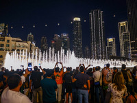 Tourists watch a water show of the Dubai Fountain at Burj Khalifa Lake in Dubai, United Arab Emirates on November 29, 2023.  (