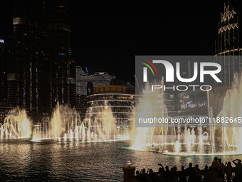 Tourists watch a water show of the Dubai Fountain at Burj Khalifa Lake in Dubai, United Arab Emirates on November 29, 2023.  (