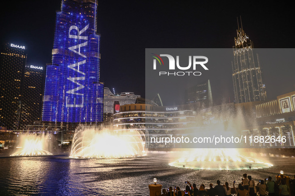 Tourists watch a water show of the Dubai Fountain at Burj Khalifa Lake in Dubai, United Arab Emirates on November 29, 2023.  