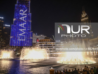 Tourists watch a water show of the Dubai Fountain at Burj Khalifa Lake in Dubai, United Arab Emirates on November 29, 2023.  (