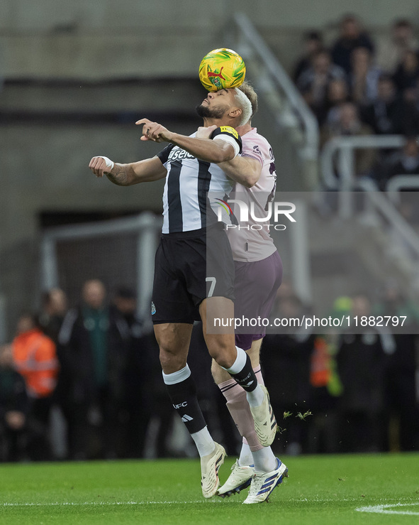 Joelinton of Newcastle United challenges Nathan Collins of Brentford for a header during the Carabao Cup Quarter Final match between Newcast...