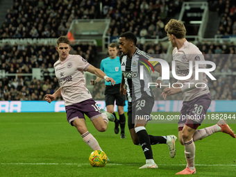 Newcastle United's Joe Willock is in action with Brentford's Mads Roerslev and Yehor Yarmolyuk during the Carabao Cup Quarter Final match be...