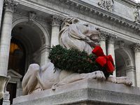 The statue of Patience the lion wears a Christmas wreath around its neck in front of the Beaux-Arts building at Fifth Avenue and 41st Street...