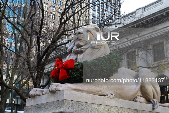 The statue of Patience the lion wears a Christmas wreath around its neck in front of the Beaux-Arts building at Fifth Avenue and 41st Street...