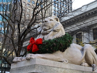 The statue of Patience the lion wears a Christmas wreath around its neck in front of the Beaux-Arts building at Fifth Avenue and 41st Street...