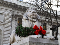 The statue of Fortitude the lion wears a mask and a Christmas wreath around its neck in front of the Beaux-Arts building at Fifth Avenue and...