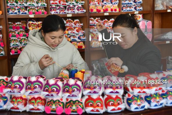 A craftsman sews tiger-head shoes in Lizhuang village, Zhangxibao town, Yongnian district, Handan city, North China's Hebei province, on Dec...