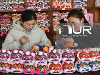 A craftsman sews tiger-head shoes in Lizhuang village, Zhangxibao town, Yongnian district, Handan city, North China's Hebei province, on Dec...