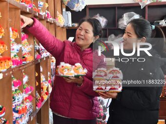 A craftsman selects tigerhead shoes for a customer in Lizhuang village, Zhangxibao town, Yongnian district, Handan, North China's Hebei prov...