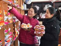 A craftsman selects tigerhead shoes for a customer in Lizhuang village, Zhangxibao town, Yongnian district, Handan, North China's Hebei prov...