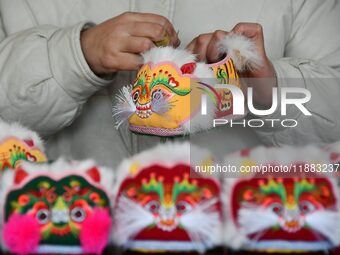 A craftsman sews tiger-head shoes in Lizhuang village, Zhangxibao town, Yongnian district, Handan city, North China's Hebei province, on Dec...