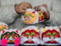 A craftsman sews tiger-head shoes in Lizhuang village, Zhangxibao town, Yongnian district, Handan city, North China's Hebei province, on Dec...