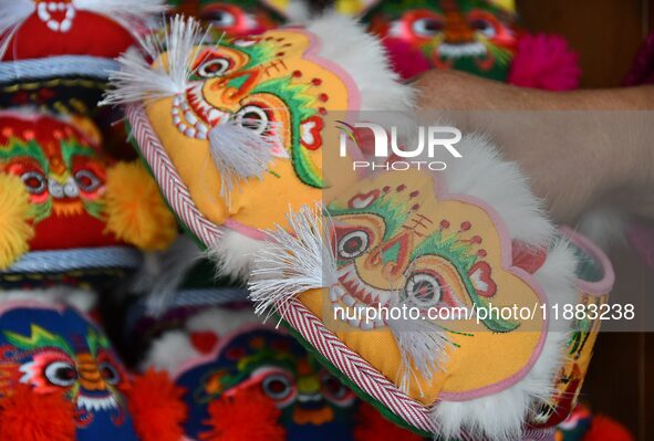 A craftsman shows tiger-head shoes in Lizhuang village, Zhangxibao town, Yongnian district, Handan, North China's Hebei province, on Decembe...