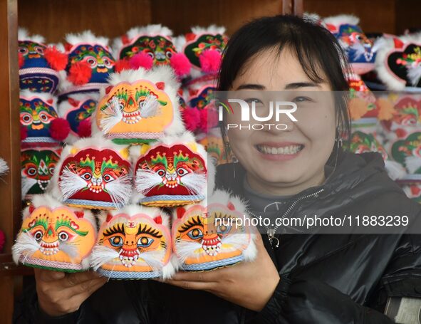 A craftsman shows tiger-head shoes in Lizhuang village, Zhangxibao town, Yongnian district, Handan, North China's Hebei province, on Decembe...