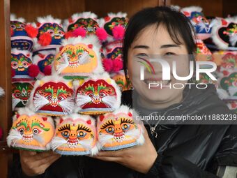 A craftsman shows tiger-head shoes in Lizhuang village, Zhangxibao town, Yongnian district, Handan, North China's Hebei province, on Decembe...