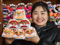 A craftsman shows tiger-head shoes in Lizhuang village, Zhangxibao town, Yongnian district, Handan, North China's Hebei province, on Decembe...