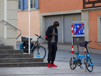 A man stands near parked bicycles while using a smartphone in Bamberg, Bavaria, Germany, on September 9, 2023. (