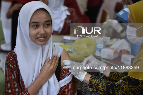 A junior high school student receives an HPV (Human Papillomavirus) vaccine injection from a medical officer in a classroom in Malang, East...