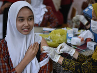 A junior high school student receives an HPV (Human Papillomavirus) vaccine injection from a medical officer in a classroom in Malang, East...