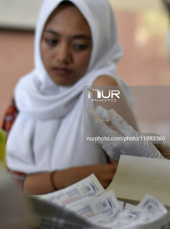 Medical personnel inject the HPV (Human Papillomavirus) vaccine into junior high school students in a classroom in Malang, East Java, Indone...