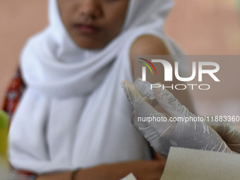 Medical personnel inject the HPV (Human Papillomavirus) vaccine into junior high school students in a classroom in Malang, East Java, Indone...