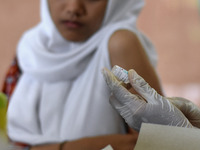 Medical personnel inject the HPV (Human Papillomavirus) vaccine into junior high school students in a classroom in Malang, East Java, Indone...