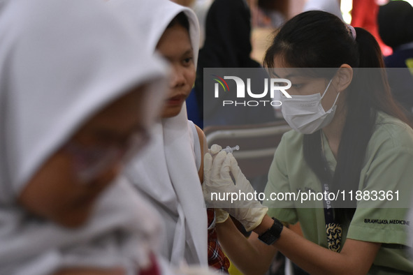 Junior high school students receive the HPV (Human Papillomavirus) vaccine from a medical officer in a classroom in Malang, East Java, Indon...