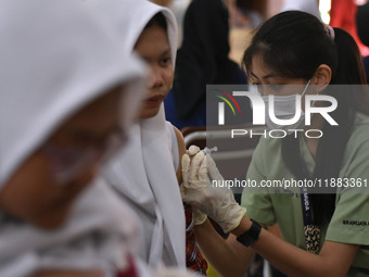 Junior high school students receive the HPV (Human Papillomavirus) vaccine from a medical officer in a classroom in Malang, East Java, Indon...