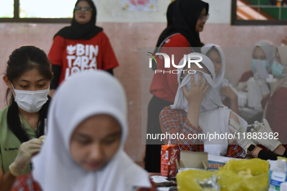 Junior high school students receive the HPV (Human Papillomavirus) vaccine from a medical officer in a classroom in Malang, East Java, Indon...