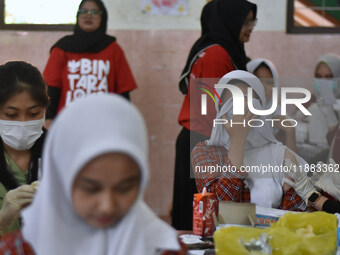 Junior high school students receive the HPV (Human Papillomavirus) vaccine from a medical officer in a classroom in Malang, East Java, Indon...