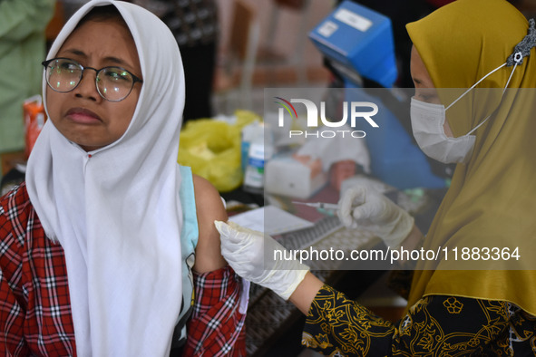 A junior high school student receives an HPV (Human Papillomavirus) vaccine injection from a medical officer in a classroom in Malang, East...