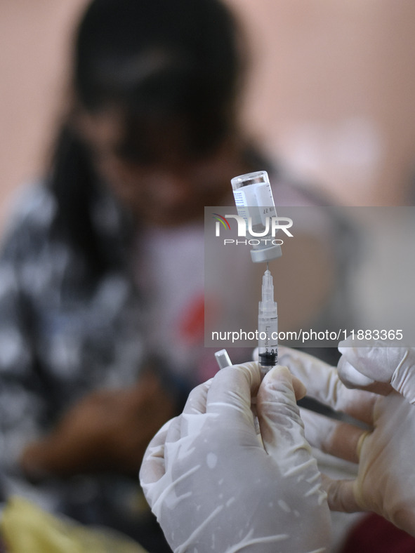 Medical personnel inject the HPV (Human Papillomavirus) vaccine into junior high school students in a classroom in Malang, East Java, Indone...